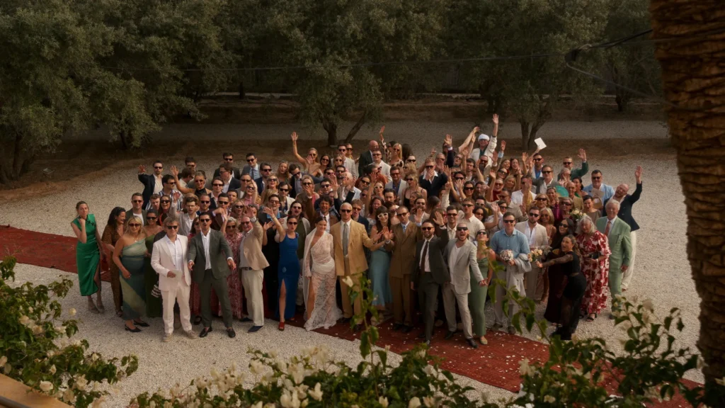 Large wedding party group photo in a Marrakesh garden, Morocco destination wedding photography