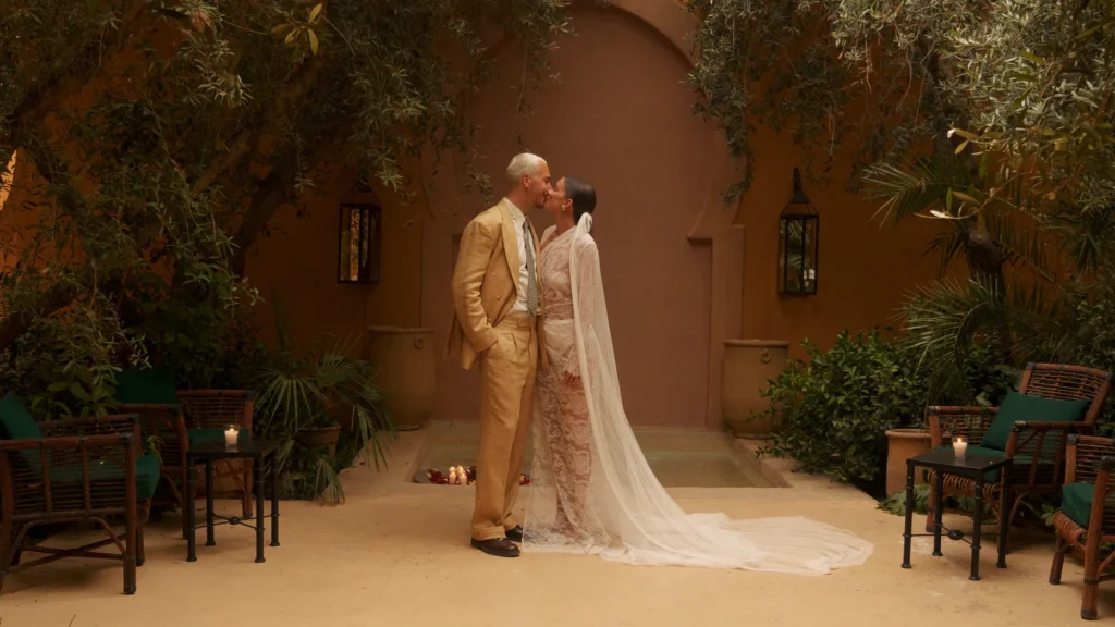 Bride and groom kissing in a Marrakesh riad courtyard, luxury Morocco destination wedding photography