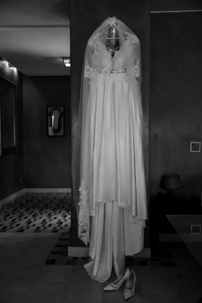 Bridal gown with long lace veil hanging in a Marrakesh riad, black and white Morocco destination wedding