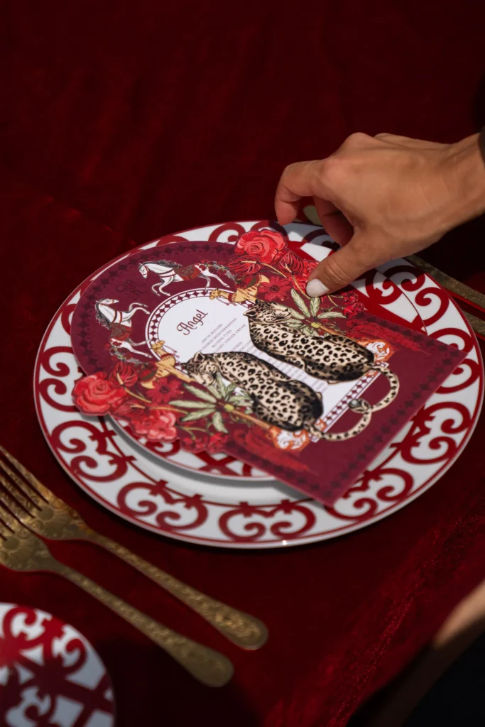 Red and gold luxury place setting with leopard menu card on red velvet, Morocco destination wedding