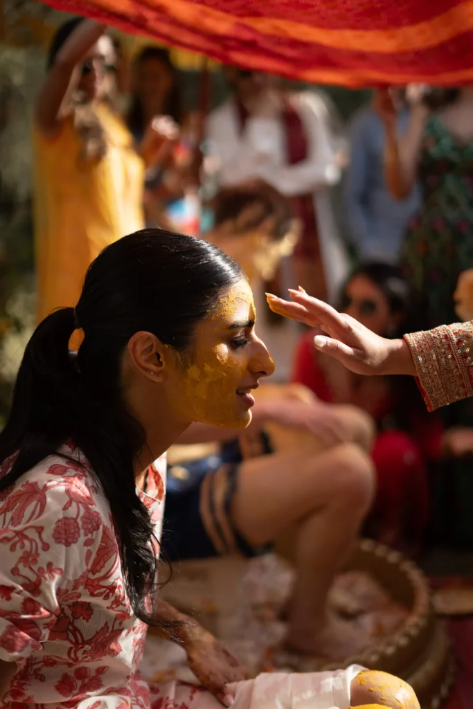 Emotional Indian bride with turmeric on her face during a haldi ceremony, Morocco destination wedding