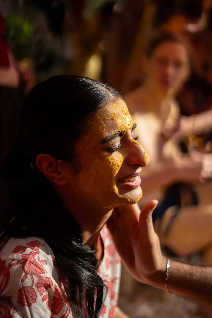 Emotional Indian bride with turmeric on her face during a haldi ceremony, Morocco destination wedding