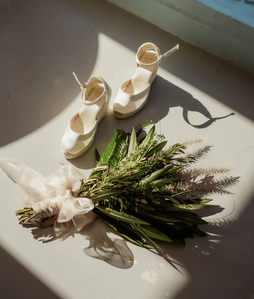 Bridal heels and a green and white bouquet in soft light, luxury Morocco destination wedding detail